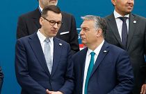 Poland's Prime Minister Mateusz Morawiecki, left, and Hungary's Prime Minister Victor Orban share a word as they line up for a group picture prior to a meeting in Portugal