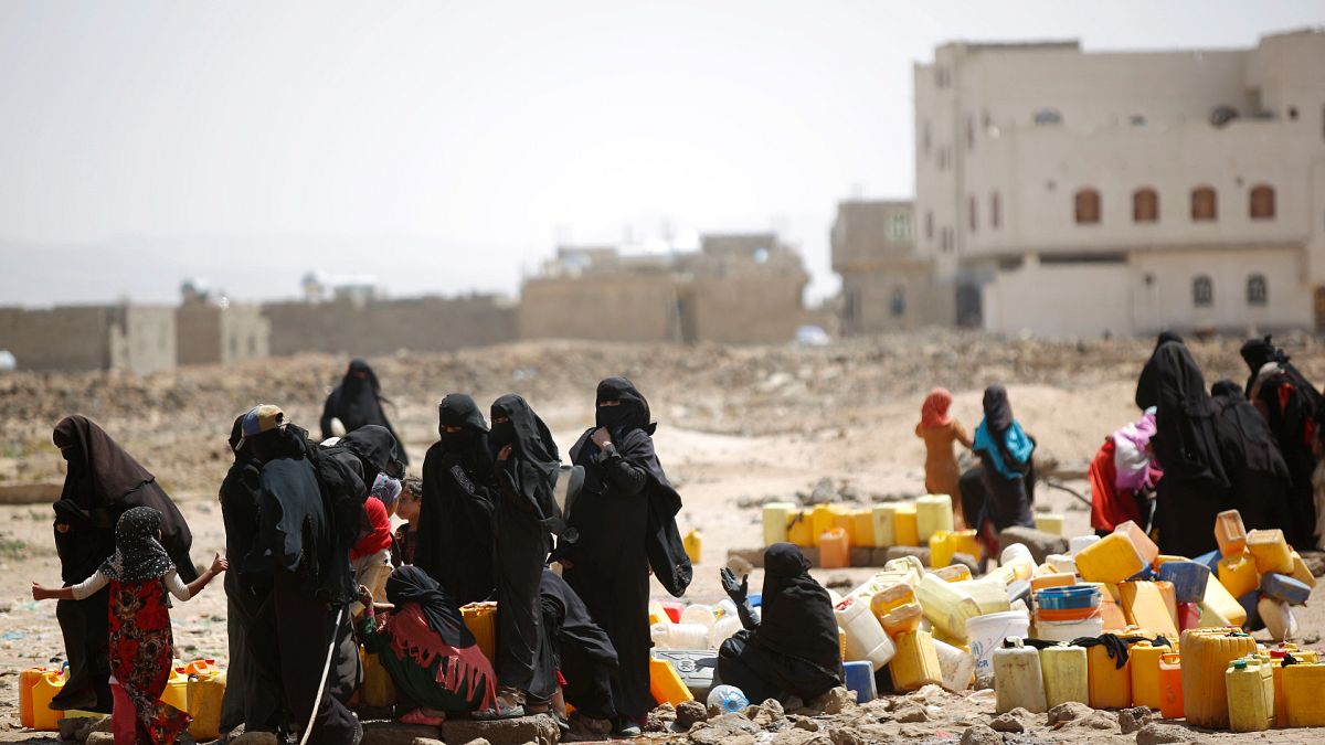 Yemen'in başkenti Sana'da su kıtlığı nedeniyle dağıtılan sudan bidonlarına dolduran kadın ve çocuklar
