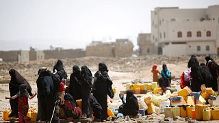 Yemen'in başkenti Sana'da su kıtlığı nedeniyle dağıtılan sudan bidonlarına dolduran kadın ve çocuklar