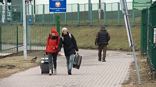 Dos personas cruzan por el paso fronterizo de  Prezemysl, en Polonia.