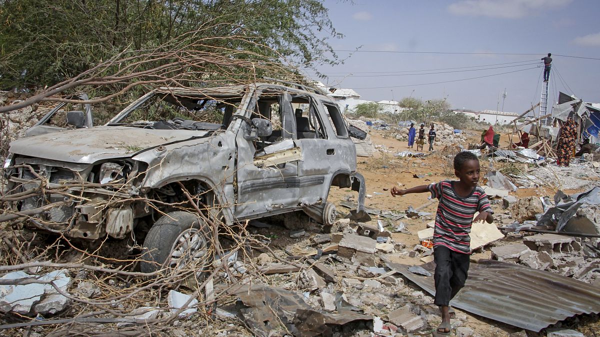 صورة لطفل يمر بالقرب من حطام سيارة دمرت في هجوم على الشرطة في العاصمة مقديشو، الصومال، في 16 فبراير 2022.