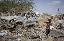 صورة لطفل يمر بالقرب من حطام سيارة دمرت في هجوم على الشرطة في العاصمة مقديشو، الصومال، في 16 فبراير 2022.