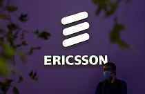 İsveçli teknoloji şirketi Ericsson'ın standı önünde telefonla konuşan bir kişi