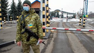 جندي أوكراني يقف عن نقطة تفتيش بالقرب من الحدود الأوكرانية الروسية