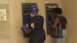 Dos mujeres retiran dinero en cajeros automáticos, 11/2/2022, La Habana, Cuba