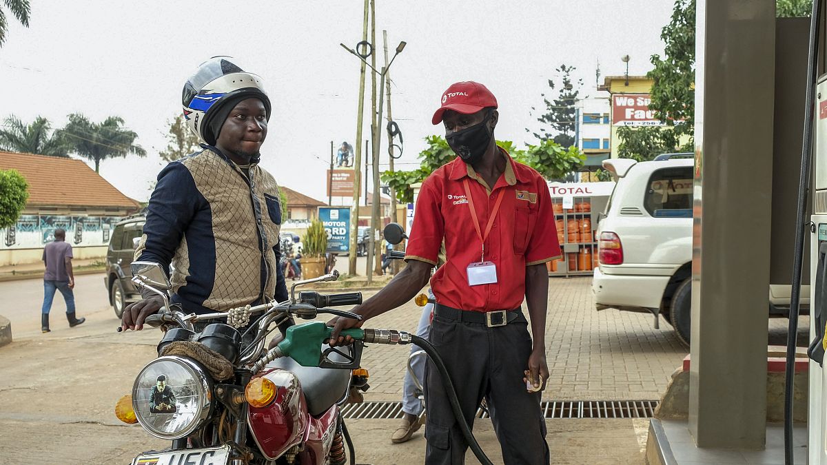 An attendant fuels a motorcycle at a Total gas station in the Kamwokya suburb of Kampala, Uganda Tuesday, Feb. 1, 2022. 