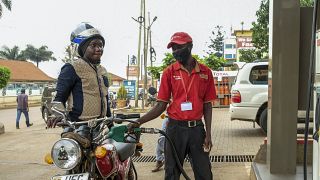 An attendant fuels a motorcycle at a Total gas station in the Kamwokya suburb of Kampala, Uganda Tuesday, Feb. 1, 2022.