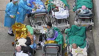 Des patients sur des lits en extérieur à Hong Kong, le 16 février 2022