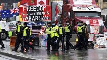 Des officiers de police marchent face aux manifestants qui bloquent Ottawa avec leurs camions, le 17 février 2022, Canada