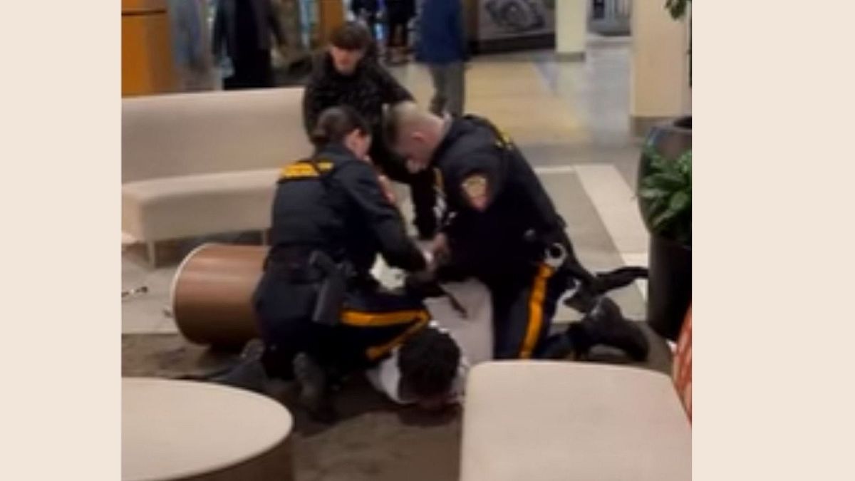 دو مامور پلیس در حال دستبند زدن به یک نوجوان سیاه پوست در مرکز خرید نیوجرسی آمریکا فوریه ۲۰۲۲