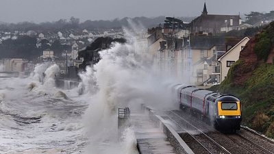 A train is battered by storm waves in Devon, England. A train is battered by storm waves in Devon, England.
