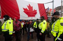 Police are followed by yelling protesters as they attempt to hand out a notices to protesters in Ottawa, on Thursday, Feb. 17, 2022.
