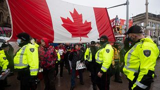 Police are followed by yelling protesters as they attempt to hand out a notices to protesters in Ottawa, on Thursday, Feb. 17, 2022.