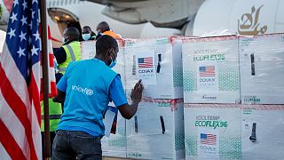 أحد العاملين في اليونيسف يتحقق من صناديق لقاح فيروس كورونا بعد وصولهم إلى المطار في نيروبي، كينيا