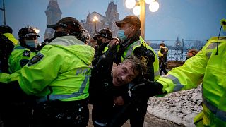 A man is arrested by police as protesters against COVID-19 measures continues to occupy downtown Ottawa, Ontario, Feb. 17, 2022.
