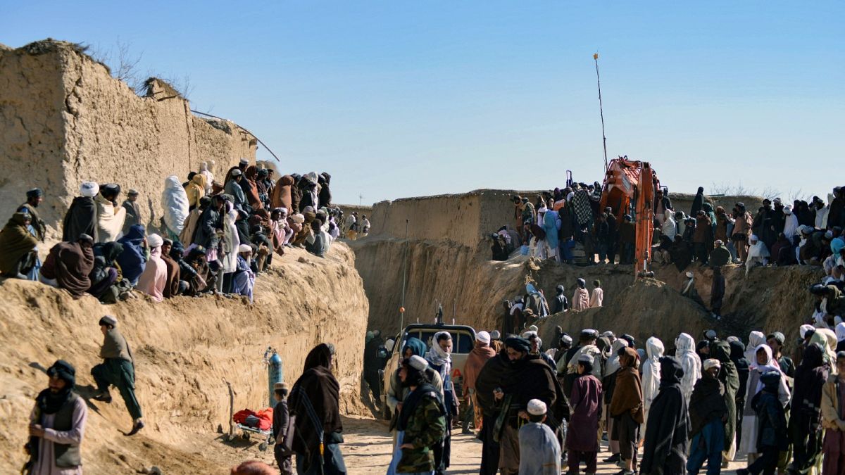 Afghan people gather as rescuers try to reach and rescue a boy trapped down a well in the Afghan village of Shokak, on February 17, 2022.
