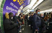 Maszkot viselő emberek egy franciaországi metróállomáson.