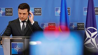 Ukraine's President Volodymyr Zelenskyy adjusts his headphone as he participates in a media conference with NATO Secretary General Jens Stoltenberg at NATO headquarters.