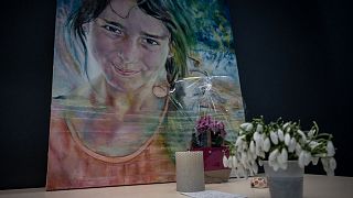 Flowers laid in front of a painting of Maelys de Araujo in the Grenoble courthouse.
