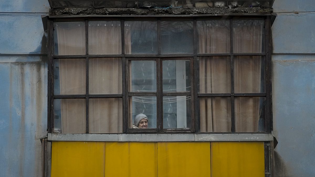 Une femme regarde par la fenêtre dans la région de Lougansk dans l'est de l'Ukraine (18/02/2022)
