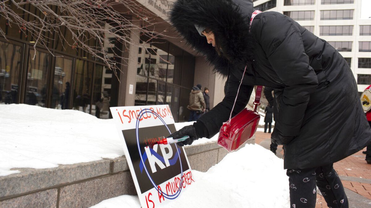 Nae Totushek writes on a I Stand With Kim Potter sign Hennepin County Government Center calling for Kim Potter's release on probation on Friday, Feb. 18, 2022 in Minneapolis. 