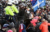 Police take action to put an end to a protest, which started over mandatory COVID vaccine mandates and grew into a wider anti-government demonstration, Feb. 18, 2022, Ottawa.