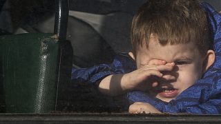 A boy waiting to be evacuated to Russia looks through the window of a bus, in Donetsk, the territory controlled by pro-Russian militants, eastern Ukraine, Sat. Feb. 19, 2022.