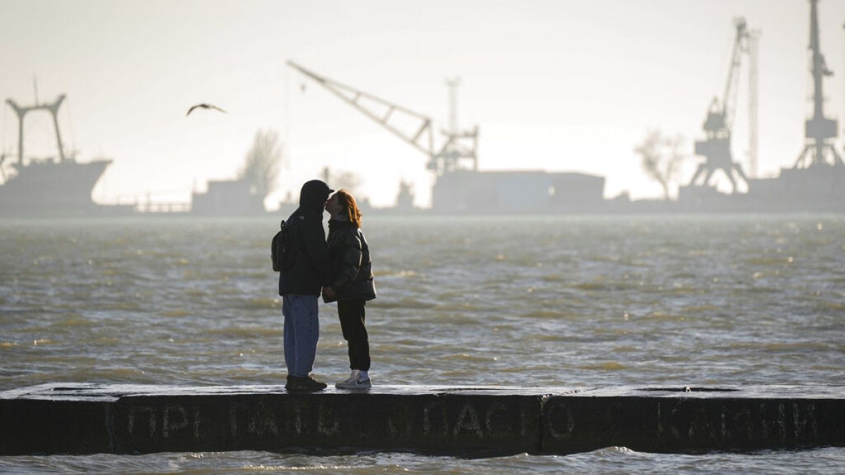 Una pareja de ucranianos se besa en el puerto de Mariupol el sábado 19 de febrero de 2022