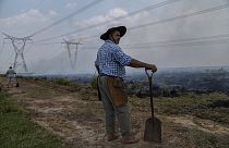 Un agricultor hace una pausa en su trabajo para ayudar a extinguir un incendio cerca de Ituzaingo, provincia de Corrientes, Argentina, el sábado 19 de febrero de 2022.