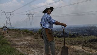 Un agricultor hace una pausa en su trabajo para ayudar a extinguir un incendio cerca de Ituzaingo, provincia de Corrientes, Argentina, el sábado 19 de febrero de 2022.