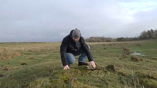 Dr. Andrew Birley inspects a well near Hadrian's Wall, UK