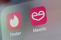 شعار تطبيقات المواعدة الأمريكي Tinder وMeetic على شاشة جهاز لوحي.
