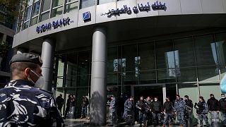 شرطة مكافحة الشغب تقف أمام أحد البنوك بعد اشتباك المودعين اللبنانيين مع الشرطة أثناء محاولتهم اقتحام بنك آخر في بيروت -الجمعة 18 فبراير 2022.