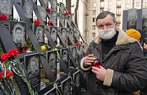 Un uomo depone dei fiori al memoriale di piazza Maidan, Kiev