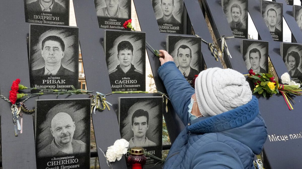 Una mujer coloca una flor en el memorial dedicado a los caídos en la revolución de Maidán, Kiev, Ucrania