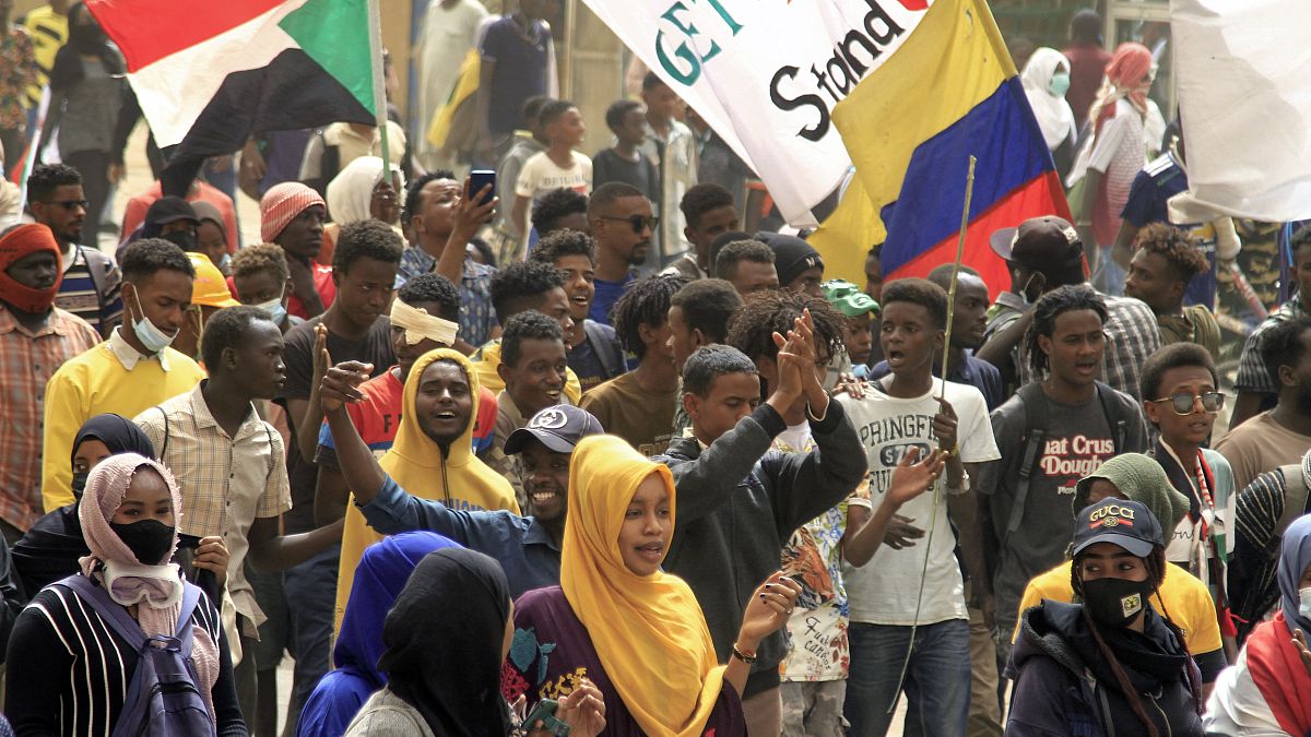متظاهرون يرفعون أعلام السودان خلال الاحتجاجات المستمرة للمطالبة بالحكم المدني والتنديد بالإدارة العسكرية  في جنوب العاصمة الخرطوم في 20 فبراير 2022.