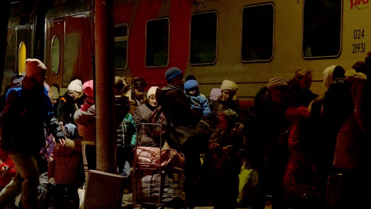 Люди, эвакуированные из самопровозглашённой Донецкой Народной Республики, стоят в очереди перед поездом для эвакуацией вглубь России. Таганрог, 20 февраля 2022 года
