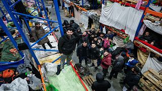 مهاجرون غير نظاميين أمام مركز الخدمات اللوجستية لنقطة تفتيش "بروزجي" على الحدود بين بولندا بالقرب من غرودن ، بيلاروس21 ديسمبر 2021.