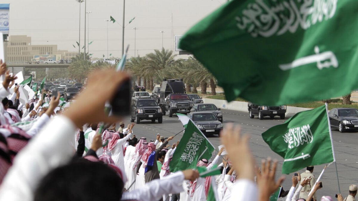 سعوديون يلوحون ويهتفون للترحيب بقافلة العاهل السعودي الملك عبد الله أثناء مروره بهم من المطار وعبر شوارع الرياض، المملكة العربية السعودية، الأربعاء 23 فبراير 2011.