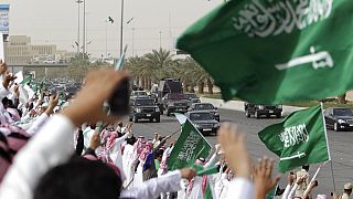 سعوديون يلوحون ويهتفون للترحيب بقافلة العاهل السعودي الملك عبد الله أثناء مروره بهم من المطار وعبر شوارع الرياض، المملكة العربية السعودية، الأربعاء 23 فبراير 2011.