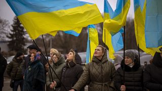 Women hold Ukrainian flags as they gather to celebrate a Day of Unity in Odessa, Ukraine, Wednesday, Feb. 16, 2022.