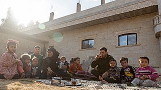 ملحم ضاهر يتناول الشاي مع أسرته خارج منزله في قرية كسرة سرور في الريف الجنوبي الشرقي لمحافظة الرقة