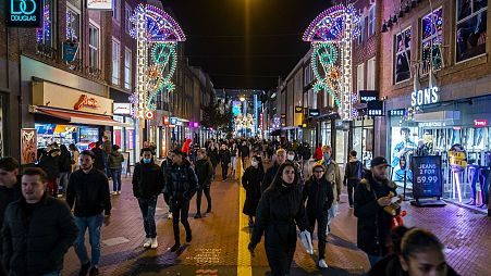 People walk in brightly lit streets of Eindhoven, the Netherlands, where energy poverty is rife.