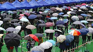 Des habitants font la queue pour passer un test de dépistage du Covid malgré la pluie, à Hong Kong, lundi 21 février 2022.