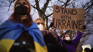 A man holds a poster in support of Ukraine as he attends a demonstration near the Russian embassy