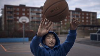 Ребенок играет в мяч в районе Стокгольма Ринкеби-Киста, где живет много иммигрантов 28 апреля 2020