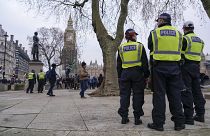 Police officers stand in London's Parliament Square during an anti-vaccines protest in January.