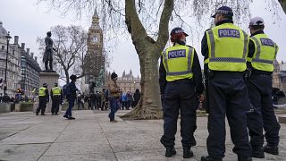 Police officers stand in London's Parliament Square during an anti-vaccines protest in January.