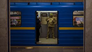 A Ukrainian army officer looks at his phone in a local train in Kyiv, Ukraine, Wednesday, Feb. 23, 2022.