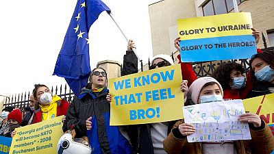 Georgian activists hold an EU flag and posters as they gather in support of Ukraine in front of the Ukrainian Embassy in Tbilisi, Georgia, Sunday, Jan. 23, 2022.